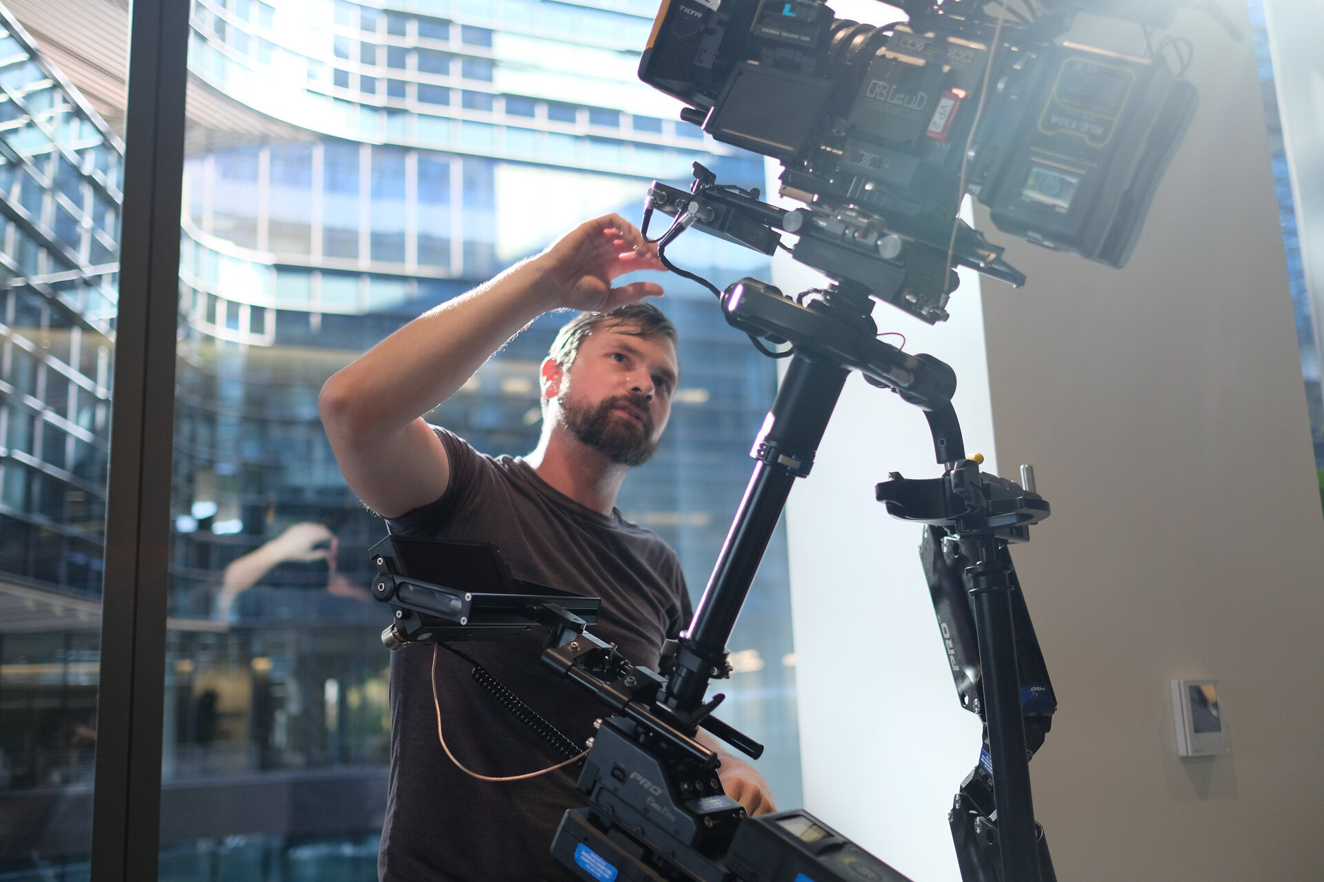 Nick Schwyter adjusting a Steadicam-mounted RED camera on location.